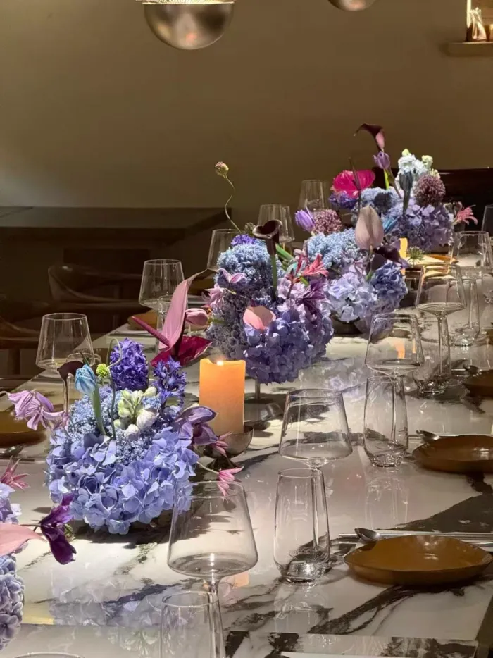 Periwinkle and lavender hydrangeas on a candlelit marble table