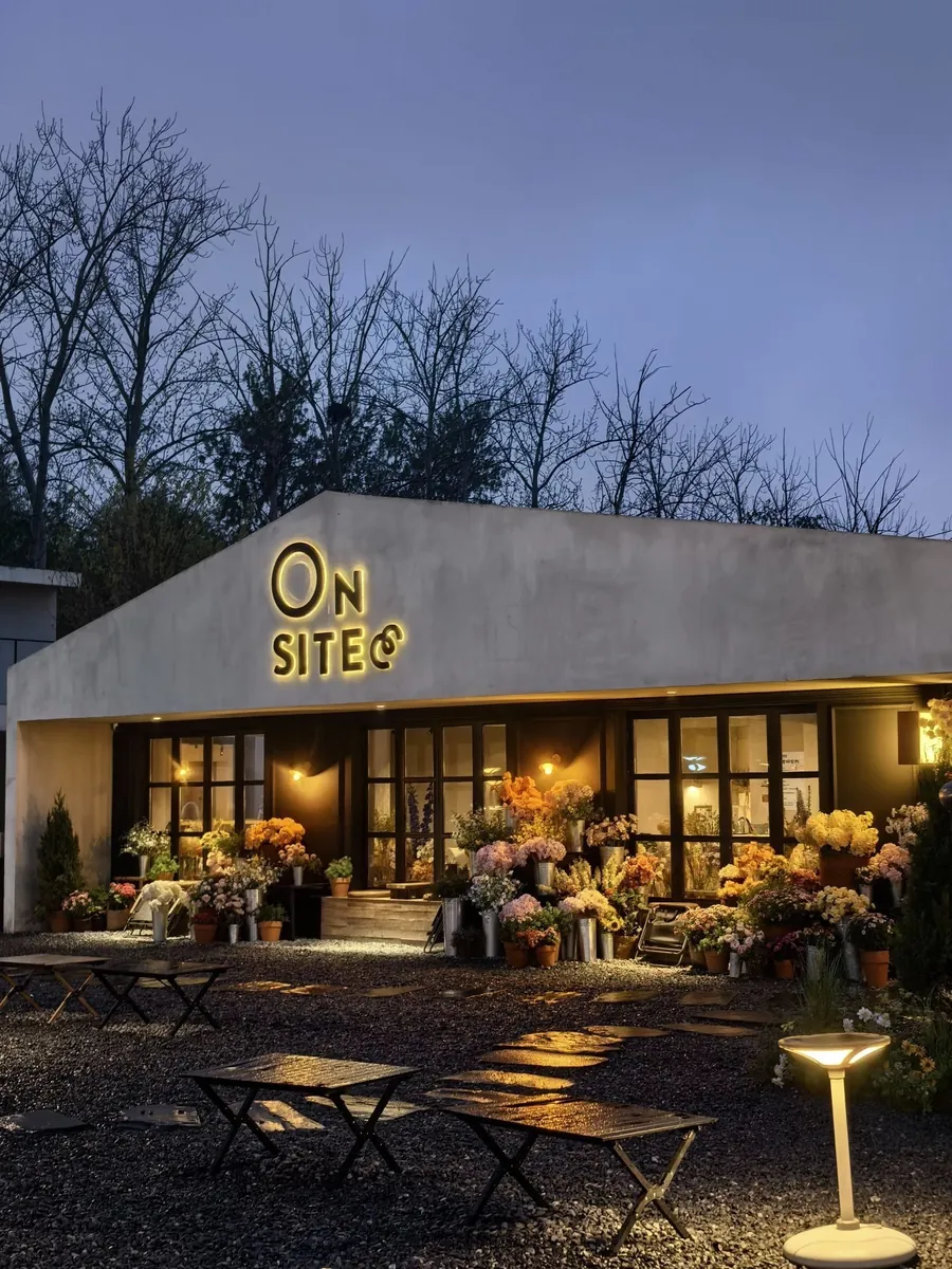 The ONSITE courtyard at dusk, with its lit sign and flowers